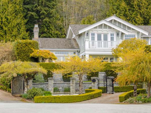 Residential community home with manicured landscaping and stone wall