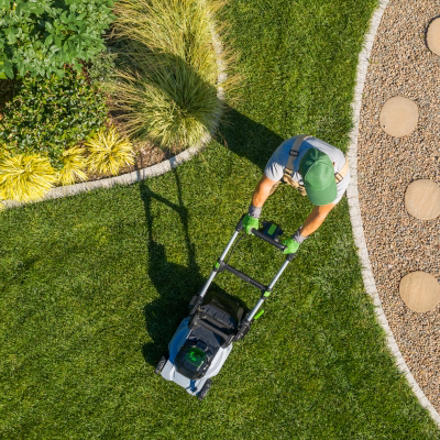 Mowing and edging a lush green lawn in summer